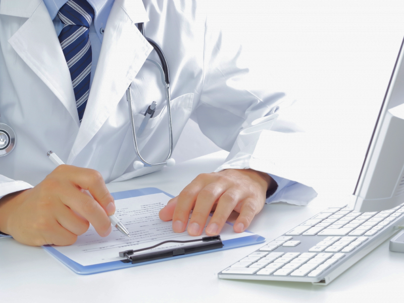 資料を記載する白衣の男性の写真