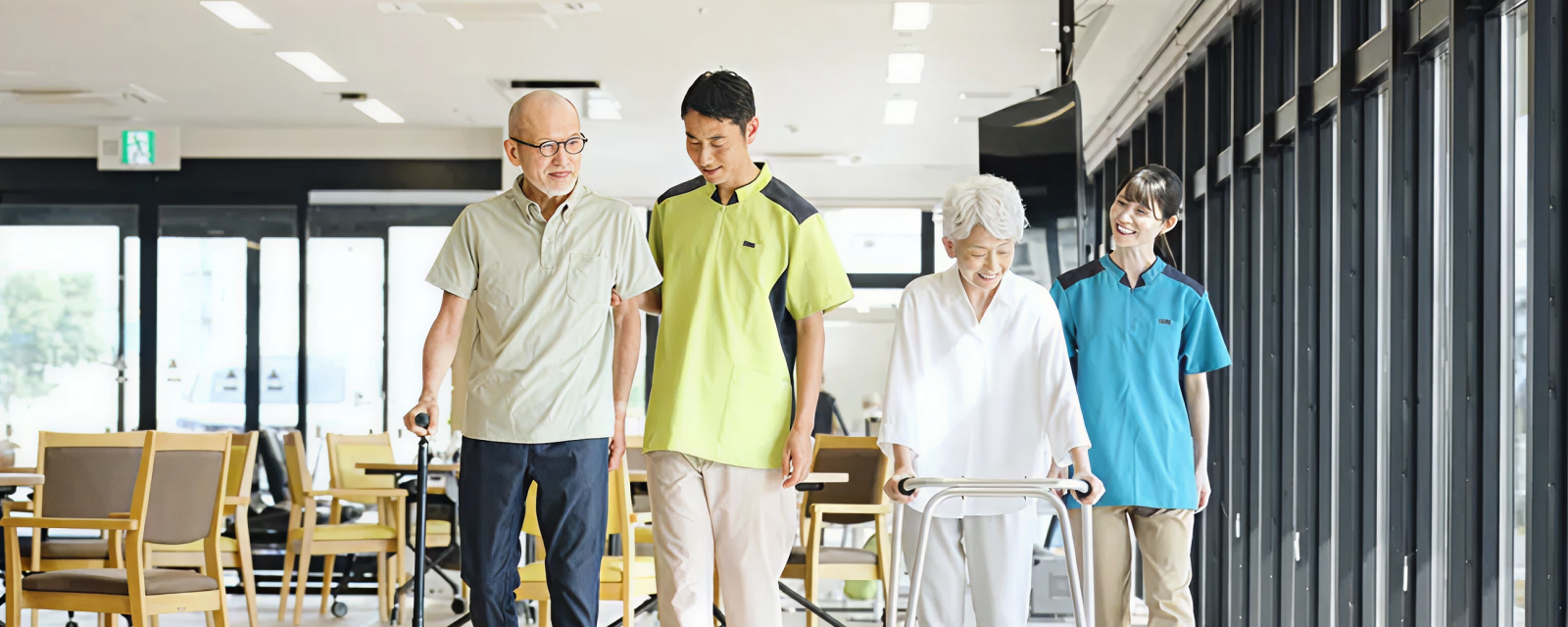 リハビリをする男女とそこにつきそう男女の写真